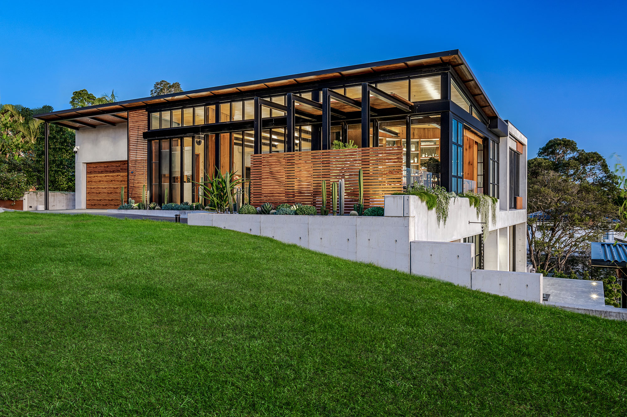 Seaforth grassy lawn leading to front of modern concrete and glass house