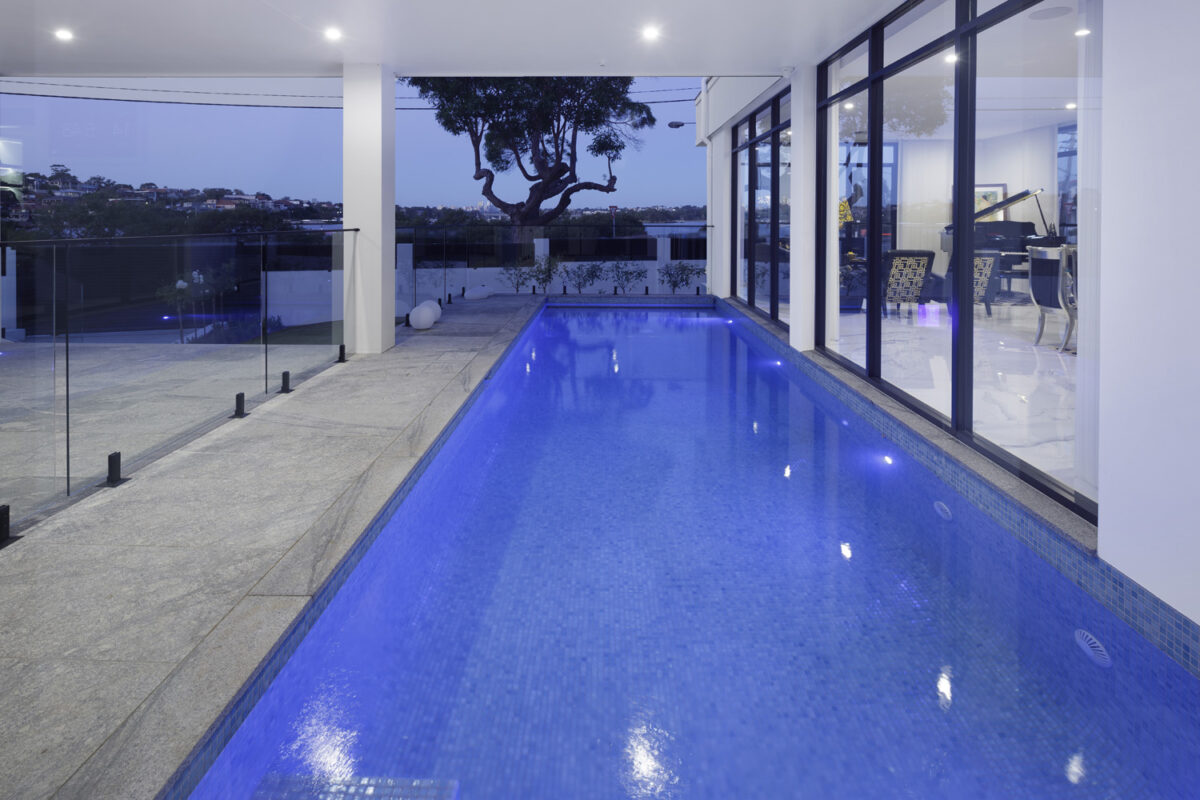 Rodd Point Contemporary: undercover pool lit up in the evening