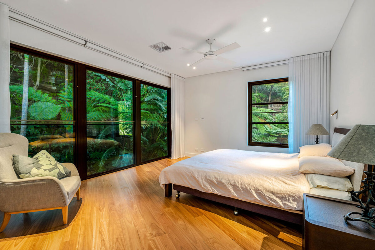 Northbridge Modern: bedroom facing an uninterrupted vista of lush greenery
